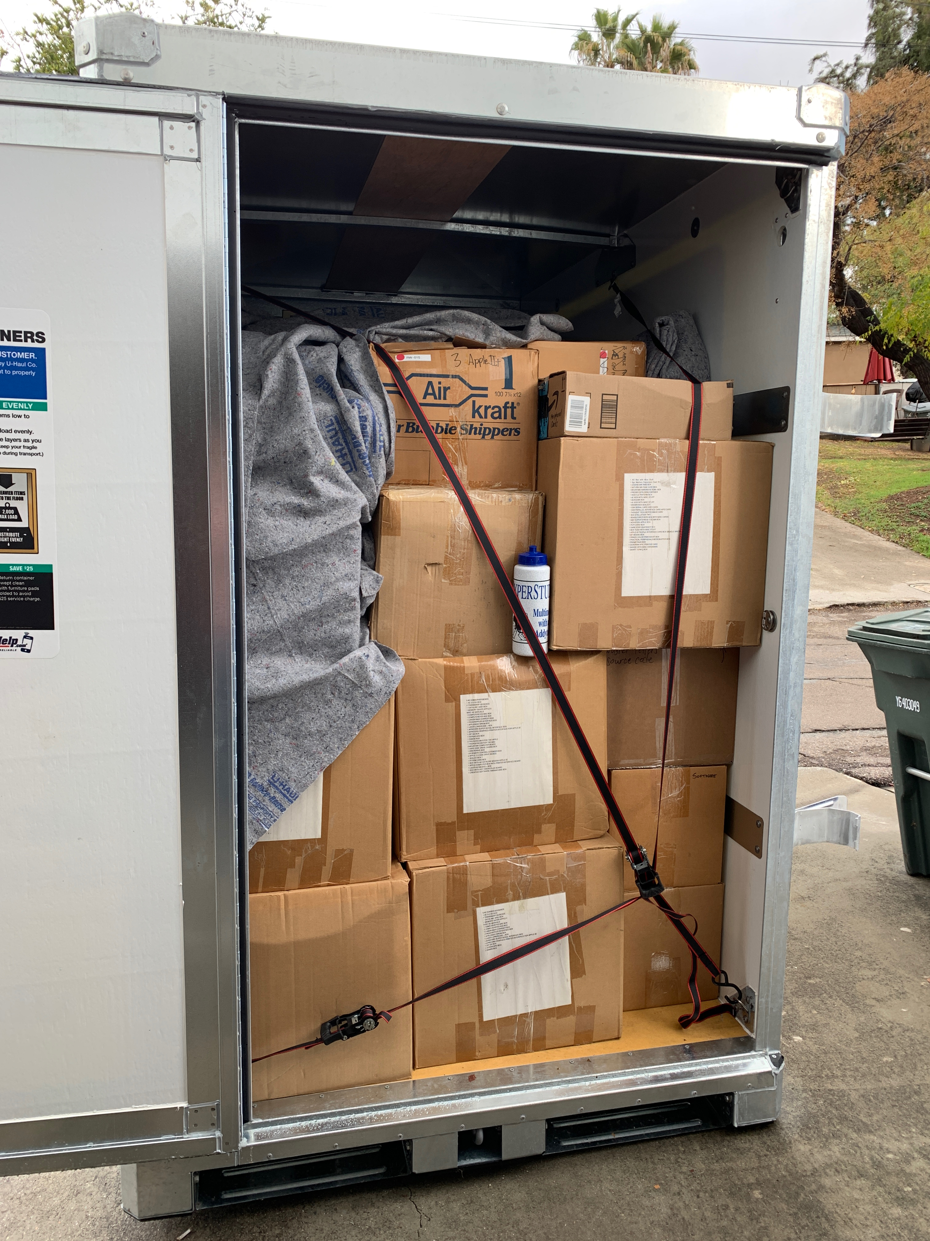 A rectangular UHaul shipping container filled with cardboard boxes