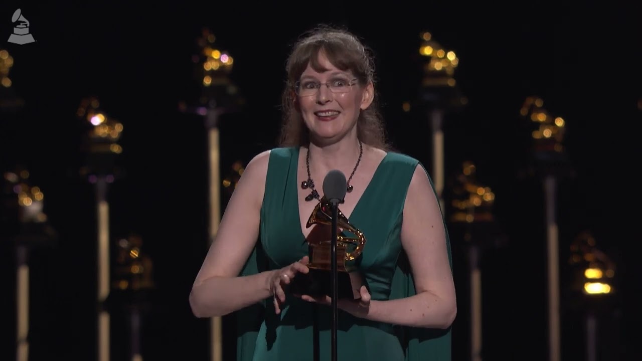Winifred Phillips holding a Grammy award on stage